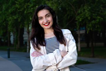 Walking brunette girl with red lips in spring. A vacation in the city