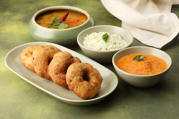 Vada / Medu vadai with sambar - Popular South Indian snack served on a steel serving plate,...