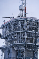 Close-up of concrete and metal communications tower on top of Titlis mountain on a sunny winter...