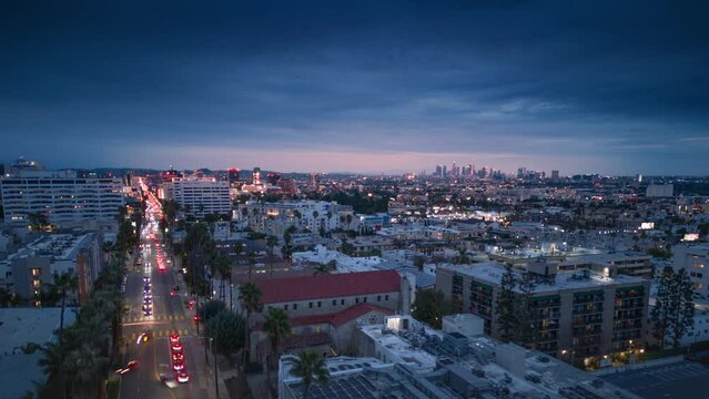 Aerial hyperlapse view of city of Los Angeles cityscape at dusk featuring traffic on Hollywood Blvd and Downton LA skyline on the horizon.