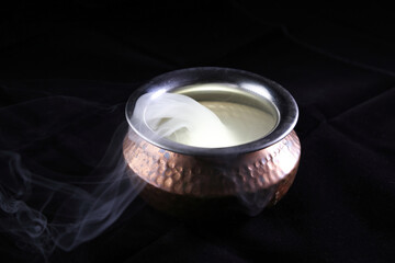 Brass copper metal style pot cauldron smoke vape fog lit inside rising flowing moving rotate on black background - 742451021