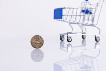 Coin one American dollar on the background of a supermarket trolley on a white background. Copy...