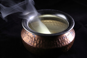 Brass copper metal style pot cauldron smoke vape fog lit inside rising flowing moving rotate on black background - 742451851