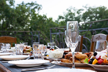 Served banquet, dining table with dishes, snacks, glasses for wine and water, European cuisine. Selective focus.
