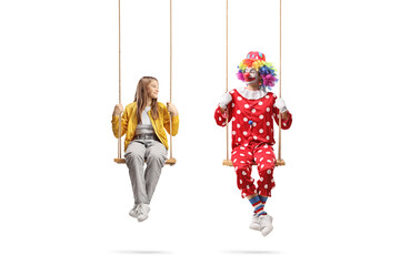 Teenage girl sitting on a swing and looking at a clown