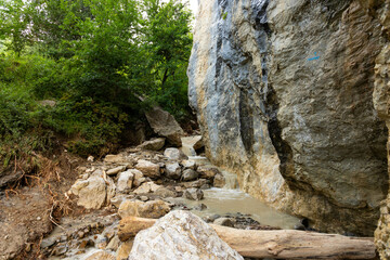 Dirty mountain river after rain, among wild rocks.