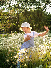 little child playing with dandelions