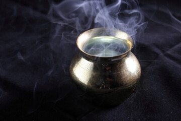 Brass copper metal style pot cauldron smoke vape fog lit inside rising flowing moving rotate on black background - 742455618