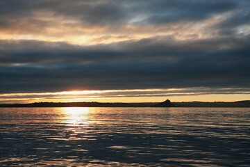Early morning silhouette of St. Michael's Mount from a yacht crossing Mount's Bay near Newlyn, Cornwall, UK