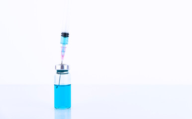 medical ampoules and syringe, on a blue background. Copy space.