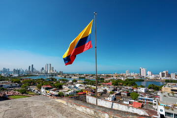 Urban skyline of Cartagena de Indias city on the Caribbean coast of Colombia. In front colombian flag. View from fortress San Felipe de Barajas Fort. - 742472032