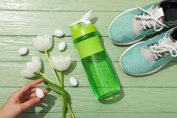 Green bottle for water, with flowers on a green background.