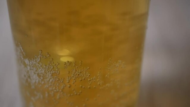 Blonde beer close up background. Bubbles of air carbon dioxide in beer float to the top. Glowing light golden ale with effervescence in a full frame background texture for for beer, brewery