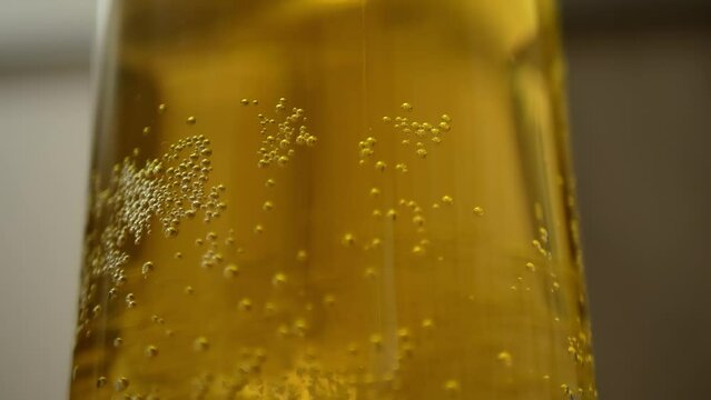 Blonde beer close up background. Bubbles of air carbon dioxide in beer float to the top. Glowing light golden ale with effervescence in a full frame background texture for for beer, brewery