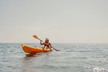 Kayak sea woman. Happy attractive woman with long hair in red swimsuit, swimming on kayak. Summer holiday vacation and travel concept.
