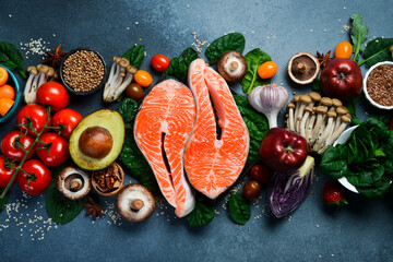 Healthy food clean eating selection: fresh fruits, berries, superfood, nuts, fish and mushrooms. On a gray concrete background. Top view.