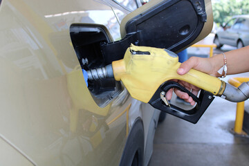 Male hand filling gasoline to the car. For petrol and gas hike news, - obrazy, fototapety, plakaty