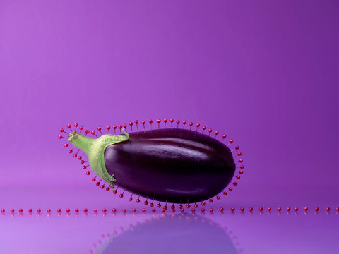 Aubergine surrounded by purple pins against a purple background
