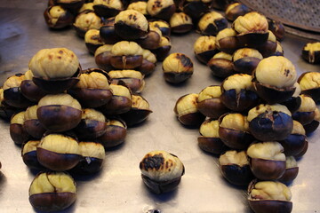 Chestnuts inside a cone with the fireplace in the background. Making roasted chestnuts at home