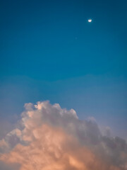 Beautiful half bright moon in the clouds with blue sky background