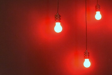 Drei Glühbirnen vor knallroter Wand