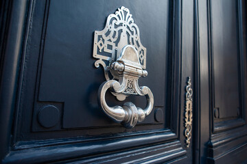 Bronze door knocker on a blue wooden door - 742523880