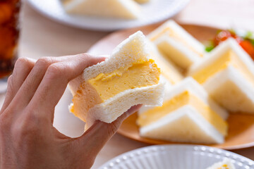 タマゴサンドを食べる男性の手元