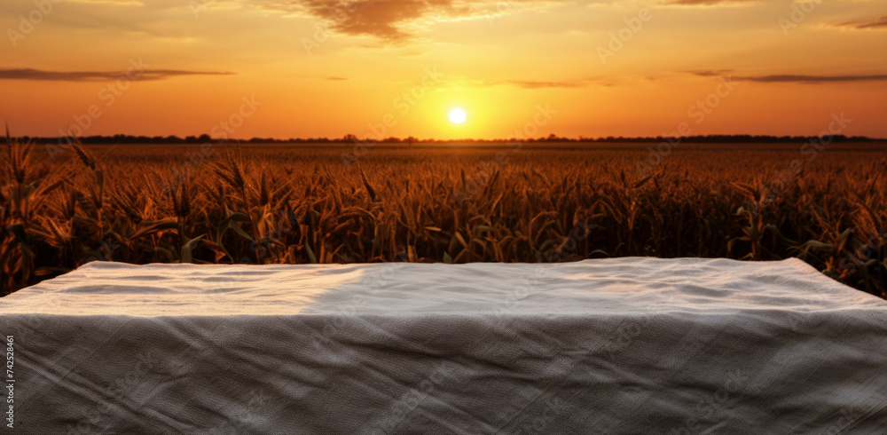 Poster empty table with tablecloth in front of a wheat field at sunset. high quality photo