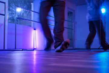 Low section of hip hop dancers legs dancing in studio with neon lights