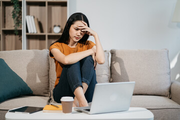 Tired asian woman with headache at office, feeling sick at work.