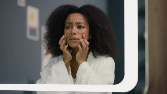 Morning beauty routine procedure African American woman ethnic girl female come in bathroom looking mirror reflection check bad complexion skin wrinkles acne black dots dissatisfied skincare problem