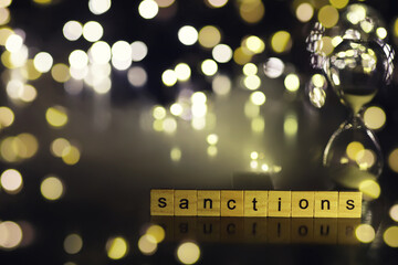 word sanctions spelled in letters on table made of wooden block letters with dramatic lighting and...