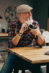 Portrait d'un photographe homme barbu chic hipster élégant et stylé qui porte un appareil photo...