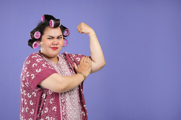 An Asian woman poses defiantly. Asian woman strong pose in front of the camera isolated in a purple...