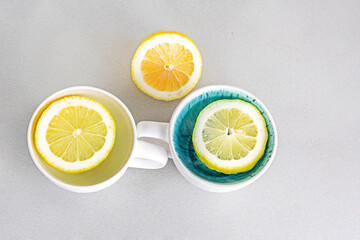 two cups with lemon slices on the table and lemon. Psychology health and attitude