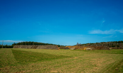 Landscape with large piles of firewood
