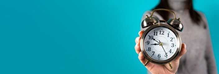 Woman holding an alarm clock in her hand