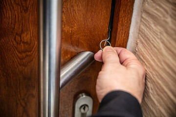 a man is using a door latch fall opening needle to open a door without damage