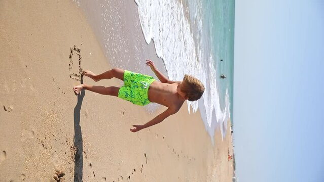 Cute little boy play with sand on summer tropical beach. Vacation concept. Happy family and childhood
