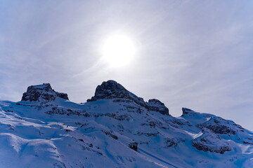 Scenic view of mountain panorama with snow covered mountain peaks and sun in the Swiss Alps at mount Titlis on a sunny winter day. Photo taken February 21st, 2024, Titlis, Engelberg, Switzerland.
