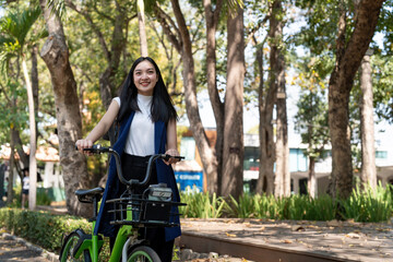 Fototapeta na wymiar Eco friendly, Happy lifestyle asian beautiful young businesswoman riding bicycle go to office work at city street with bicycle in morning