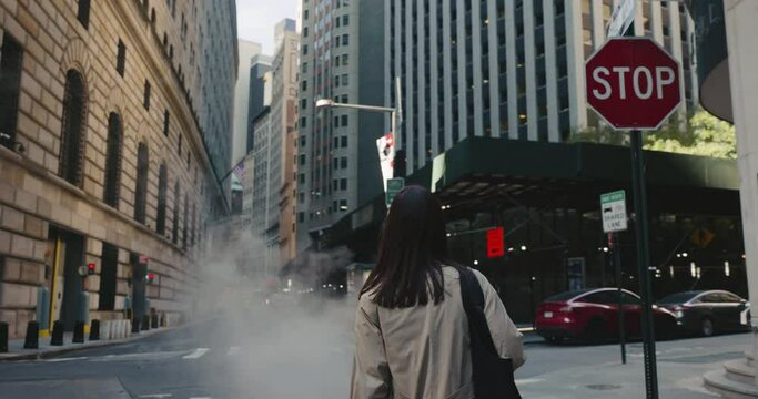 Camera follows a brunette woman as she walks and looks around the urban city streets of New York