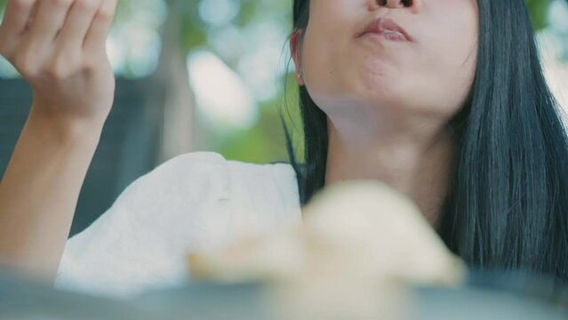 Close up shot of asian female having a big bite of cake, chewing action showing delicious supper, calories intake per day, human metabolism system, eating healthy, food hygiene and bacteria in food