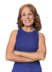 Redhead mid-aged Caucasian woman in studio who feels confident, crossing arms with determination.