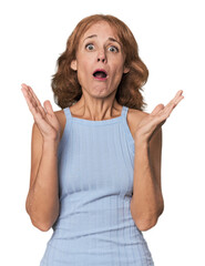 Redhead mid-aged Caucasian woman in studio surprised and shocked.