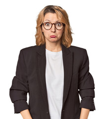 Caucasian woman in black business suit shrugs shoulders and open eyes confused.