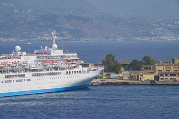 Classic cruiseship cruise ship liner Celebration docked at pier in Messina Sicily port, Italy during Summer Mediterranean cruising near Taormina