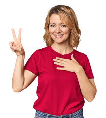 Blonde middle-aged Caucasian woman in studio taking an oath, putting hand on chest.