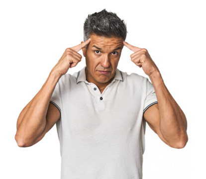 Middle-aged Latino man focused on a task, keeping forefingers pointing head.