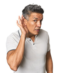 Middle-aged Latino man trying to listening a gossip.